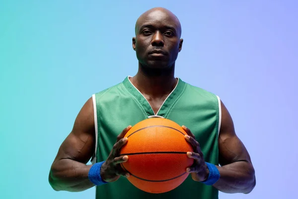 緑色から青色の背景にバスケットボールを持つアフリカ系アメリカ人バスケットボール選手のイメージ スポーツ 競技の概念 — ストック写真