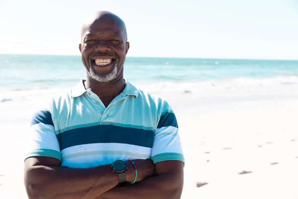 微笑着的非洲裔美国秃头老人 双臂交叉地站在海景和晴朗的天空中 复制空间 不变的生活方式 享受和自然 — 图库照片