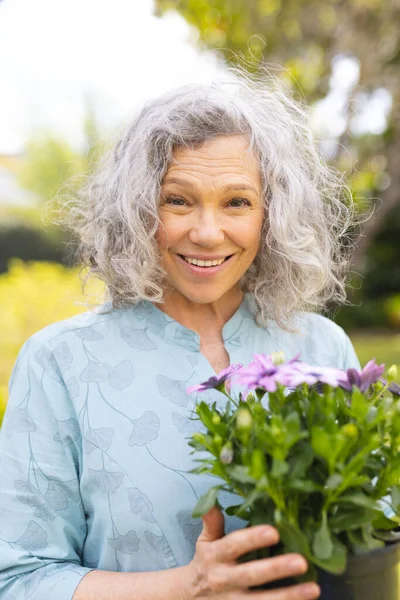 白种人老年妇女花时间在花园种植的垂直肖像 — 图库照片