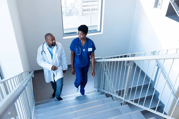 Alto Ángulo Mujer Afroamericana Médico Masculino Hablando Escalera Del Hospital —  Fotos de Stock