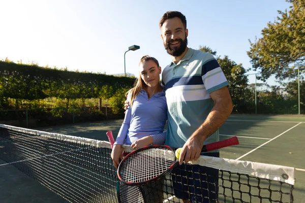 照片上 一对快乐的高加索夫妇在网球场上摆弄球拍 一起度过积极的美好时光 — 图库照片