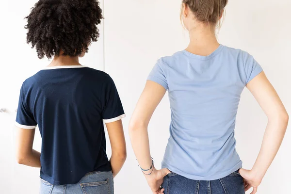 两个不同的女人穿着带有彩色空间和斜纹棉布裤子的T恤衫的后视镜图像 时装和休闲装概念 — 图库照片