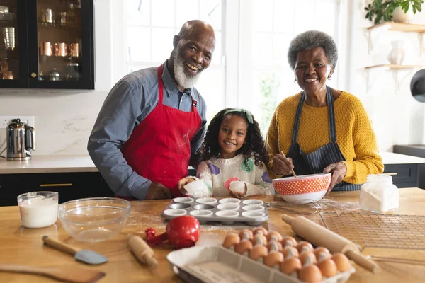 幸せなアフリカ系アメリカ人の祖父母と孫娘が台所で焼く姿 家族と一緒に質の高い時間を過ごすコンセプト — ストック写真