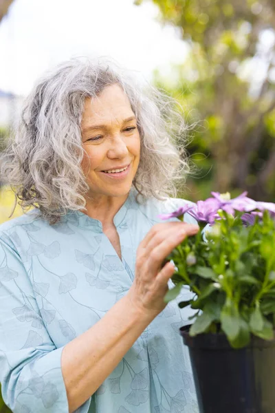 白种人老年妇女花时间在花园种植的垂直肖像 — 图库照片