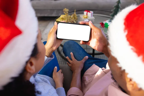 Afrykańska Para Kapeluszach Świętego Mikołaja Używająca Smartfona Przestrzenią Kopiowania Spędzanie — Zdjęcie stockowe