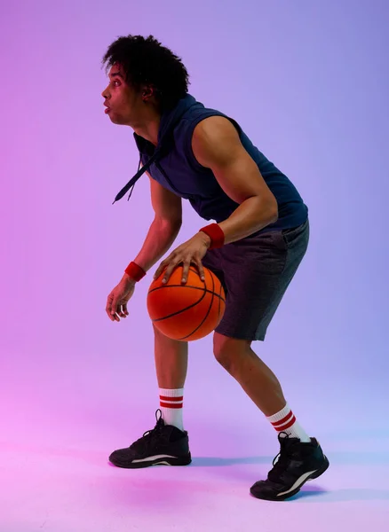 紫から青の背景にバスケットボールを持つ出生バスケットボール選手のイメージ スポーツ 競技の概念 — ストック写真