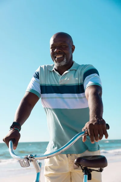 Χαμογελώντας Φαλακρός Αφροαμερικάνος Ανώτερος Άνδρας Ιππεύει Ποδήλατο Στην Παραλία Κάτω — Φωτογραφία Αρχείου