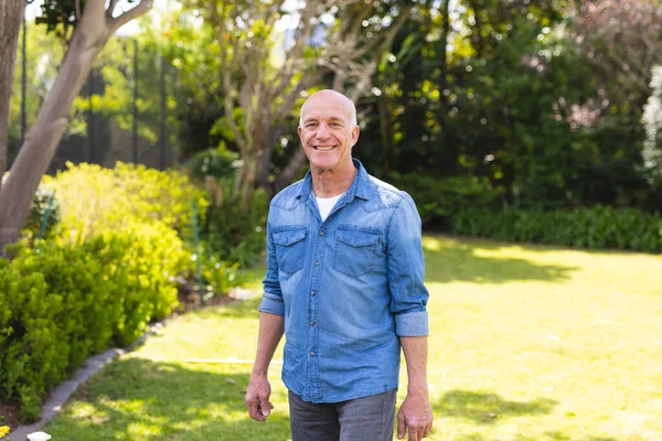 穿着蓝色衬衫站在花园里的高个子高加索人的画像 一个人呆在外面 — 图库照片