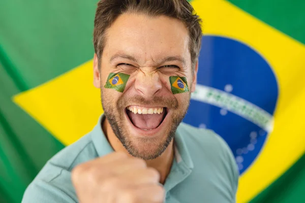 Obraz Szczęśliwego Białego Człowieka Flagami Brazylii Twarzy Nad Flagą Brazylii — Zdjęcie stockowe