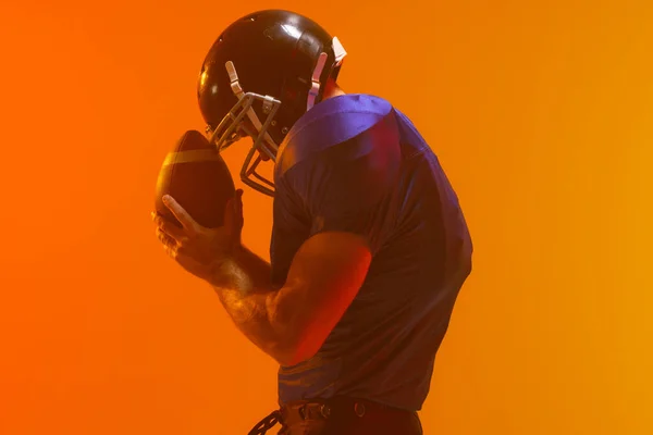Jugador Fútbol Americano Masculino Caucásico Sosteniendo Pelota Con Iluminación Naranja —  Fotos de Stock