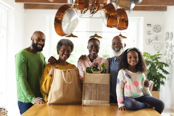 形象快乐的非洲裔美国多代家庭与购物袋在厨房 家庭与共同度过美好时光的概念 — 图库照片