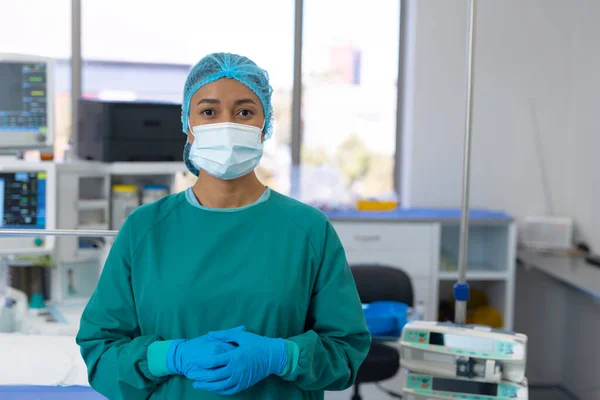 Portrét Biraciálního Chirurga Čepici Rukavicích Masce Šatech Operačním Sále Nemocniční — Stock fotografie