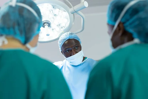 アフリカ系アメリカ人男性外科医は 手術中 コピースペースで劇場の同僚と話しています 医療サービス — ストック写真
