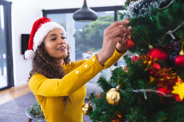 Šťastná Afroameričanka Klobouku Santa Clause Zdobí Vánoční Stromeček Obývacím Pokoji — Stock fotografie
