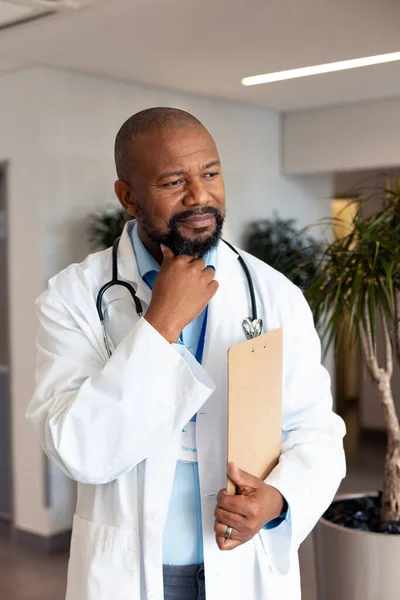 Vertical Thoughtful African American Male Doctor Clipboard Hospital Corridor Hospital — Stock Photo, Image
