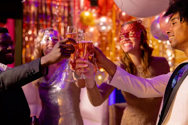 ナイトクラブのパーティーでシャンパンをグラスで乾杯する4人の幸せで多様な友人 楽しさ 包括性 お祝いとパーティーのコンセプト — ストック写真