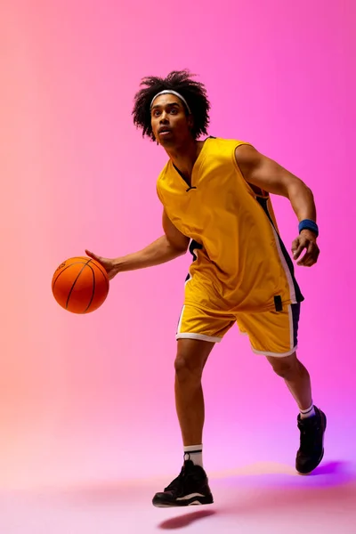 Afbeelding Van Biracial Basketbalspeler Stuiteren Basketbal Neon Roze Achtergrond Concept — Stockfoto