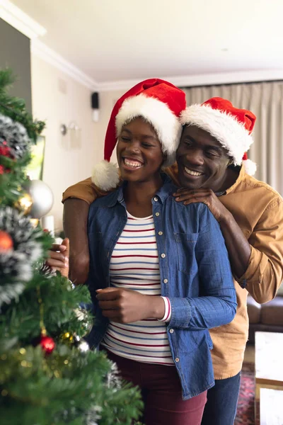 アフリカ系アメリカ人の夫婦が一緒に時間を過ごし クリスマスツリーを飾る垂直写真 クリスマス 家族の時間とお祝いの概念 — ストック写真