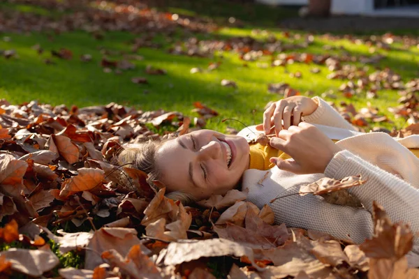 Χαρούμενη Λευκή Γυναίκα Ξαπλωμένη Στα Φθινοπωρινά Φύλλα Και Χαμογελαστή Περνώντας — Φωτογραφία Αρχείου