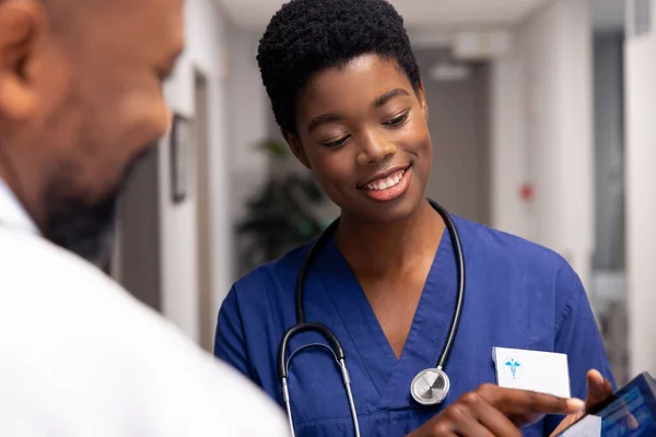 Gülümseyen Afro Amerikan Erkek Kadın Doktor Hastane Koridorunda Tablet Kullanıyor — Stok fotoğraf