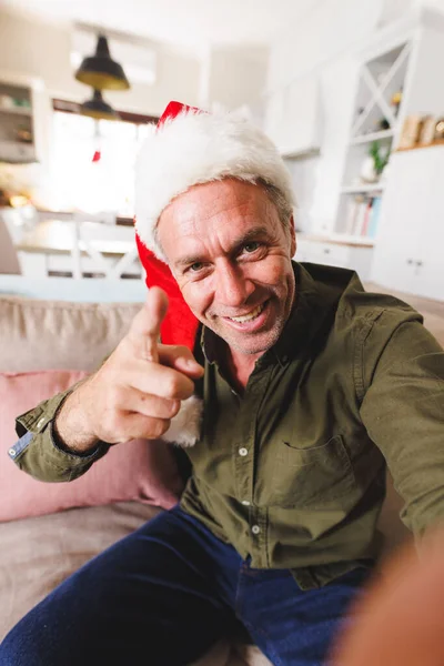 Homem Caucasiano Feliz Vestindo Chapéu Papai Noel Sentado Sofá Sala — Fotografia de Stock
