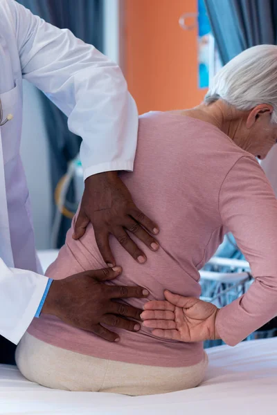Vertical Diverse Senior Male Doctor Examining Back Senior Female Patient — Photo