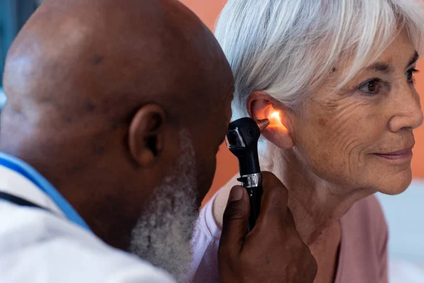 Médico Masculino Sênior Diverso Usando Otoscópio Examinando Orelha Paciente Sênior — Fotografia de Stock