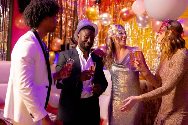 ナイトクラブのパーティーでシャンパンを飲みながら話をする4人の幸せで多様な友人 楽しさ 飲み物 包括性とパーティーのコンセプト — ストック写真