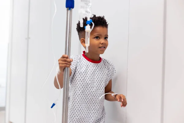 笑着非洲裔美国男孩患者与滴滴站在医院走廊与复制空间 医疗和保健服务 — 图库照片