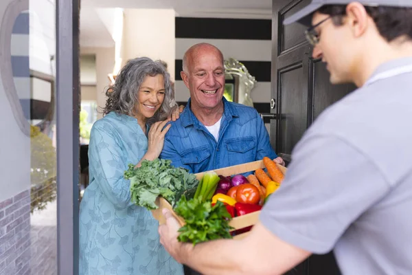 Happy Senior Caucasian Couple Opening House Door Welcoming Courier Vegetables — 스톡 사진