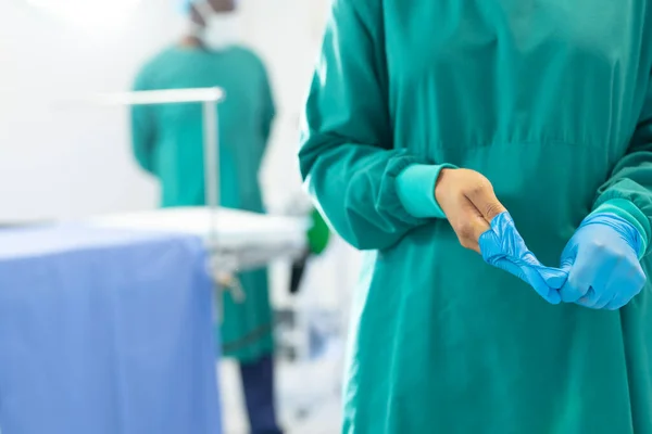 Cerrahi Önlüklü Kadın Cerrahın Orta Kısmı Ameliyathanede Eldiven Çıkarıyor Fotokopi — Stok fotoğraf