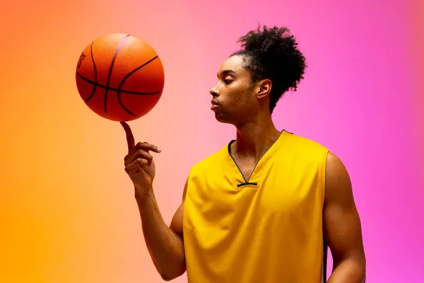 Afbeelding Van Biracial Basketballer Spinnen Basketbal Roze Tot Oranje Achtergrond — Stockfoto