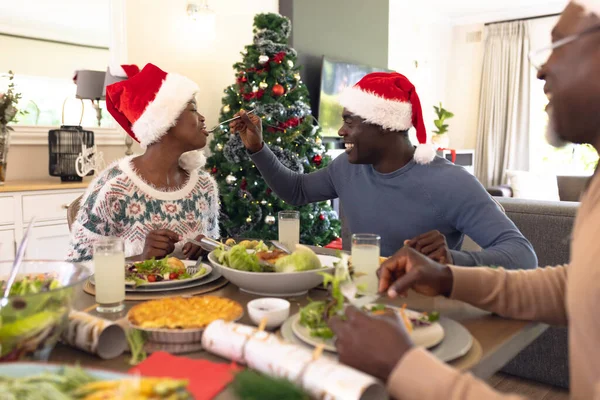 アフリカ系アメリカ人の家族はクリスマスの食事を持ってテーブルで一緒に時間を過ごす クリスマス 家族の時間とお祝いの概念 — ストック写真