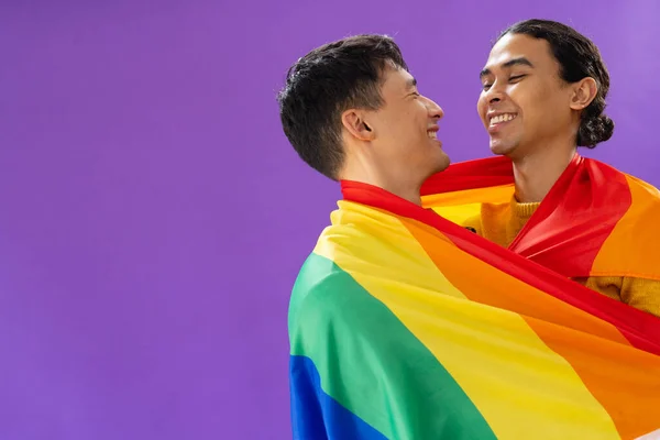 Happy Biracial Male Couple Embracing Holding Lgbt Flag Purple Background — Stock Photo, Image