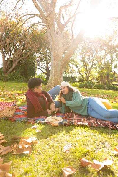 Szczęśliwa Para Dwurasowa Leżąca Dywanie Robiąca Piknik Rozmawiająca Jesiennym Ogrodzie — Zdjęcie stockowe
