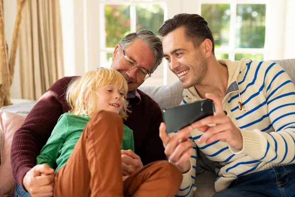 Imagem Homens Caucasianos Felizes Três Gerações Sentados Sofá Usando Smartphone — Fotografia de Stock