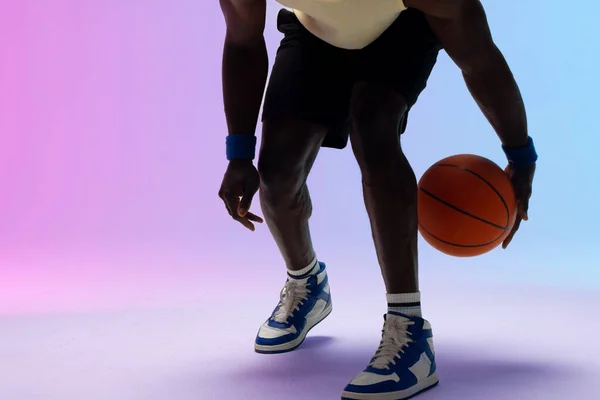 ネオン紫から青の背景にバスケットボールでアフリカ系アメリカ人のバスケットボール選手のイメージ スポーツ 競技の概念 — ストック写真