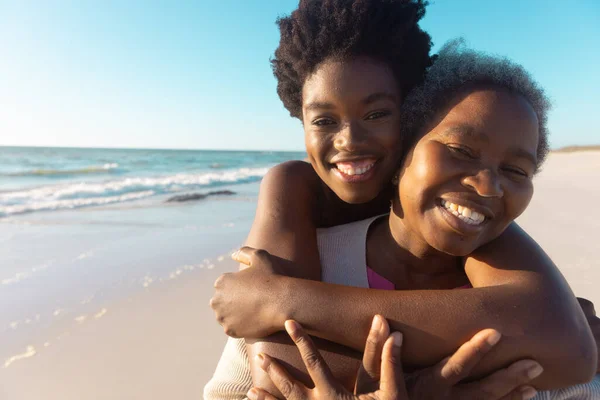 在海空相映成趣的海滩上拥抱年长母亲的非洲裔美国女子的画像 复制空间 享受和自然 — 图库照片