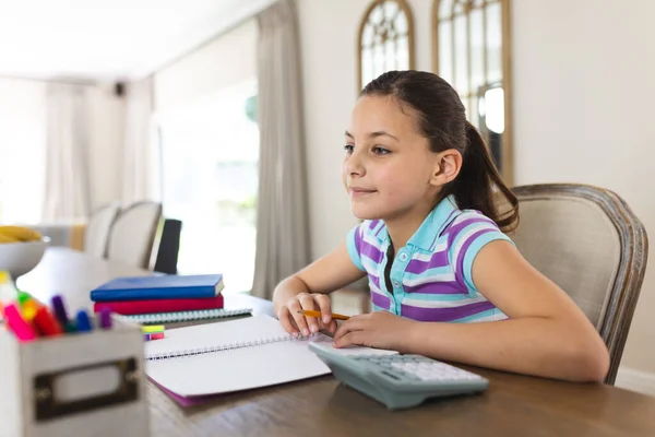 快乐的高加索女孩在客厅学习 并在笔记本上记笔记 家庭教育 远距离教育 — 图库照片