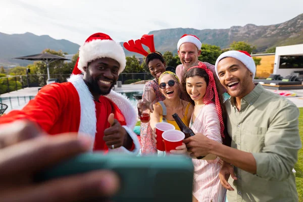 Szczęśliwi Zróżnicowani Przyjaciele Kapeluszach Mikołaja Robiący Selfie Ogrodzie Boże Narodzenie — Zdjęcie stockowe