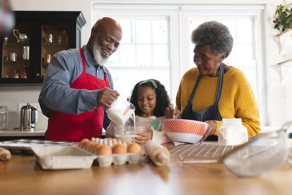 幸せなアフリカ系アメリカ人の祖父母と孫娘が台所で焼く姿 家族と一緒に質の高い時間を過ごすコンセプト — ストック写真