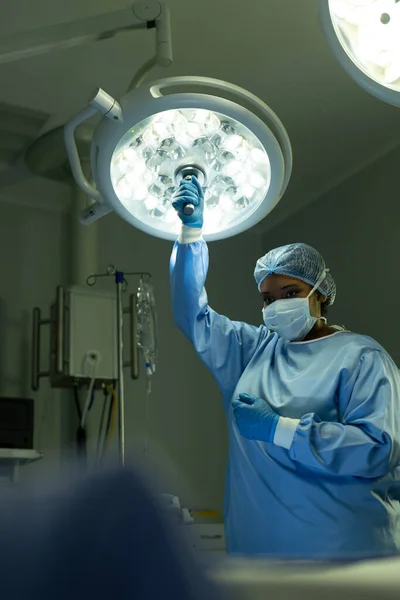 Vertical Tecnologia Cirúrgica Feminina Biracial Ajustando Luz Teatro Operações Com — Fotografia de Stock