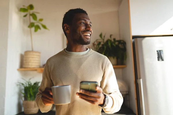 Homem Americano Africano Feliz Usando Smartphone Beber Café Cozinha Passar — Fotografia de Stock