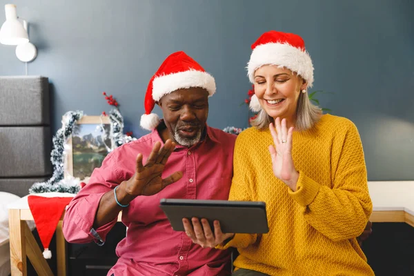 Feliz Diversa Pareja Ancianos Sombreros Santa Haciendo Videollamada Navidad Saludando — Foto de Stock