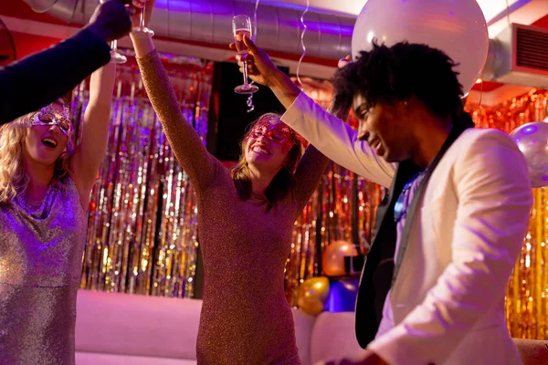 ナイトクラブのパーティーでシャンパンのグラスを持ち上げる4人の幸せで多様な友人 楽しさ 包括性 お祝いとパーティーのコンセプト — ストック写真