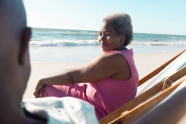 Smiling African American Senior Woman Talking Man While Relaxing Deckchairs — Stock Photo, Image