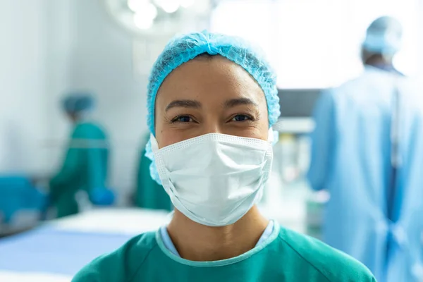 Ameliyathanede Cerrahi Maske Şapka Takmış Gülümseyen Çift Irklı Kadın Cerrahın — Stok fotoğraf