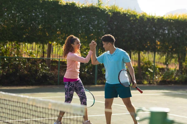 Usmívající Biracial Pár Hraje Tenis Třesoucí Ruce Slunném Venkovním Tenisovém — Stock fotografie