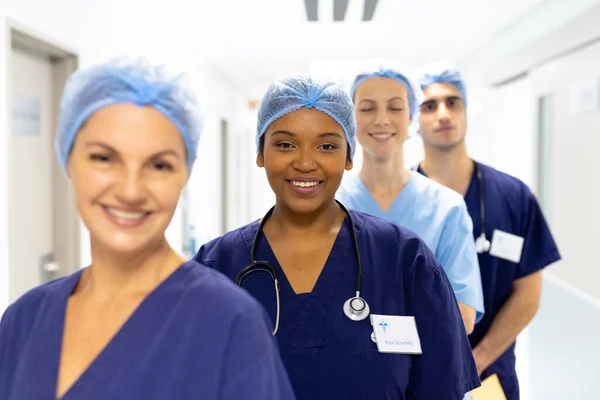 不同类别的医护人员在医院走廊里戴着外科帽微笑的画像 医疗和保健服务 — 图库照片
