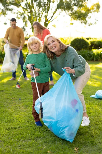 正面形象快乐的高加索祖母和孙子与垃圾袋在花园 回收和生态意识概念 — 图库照片